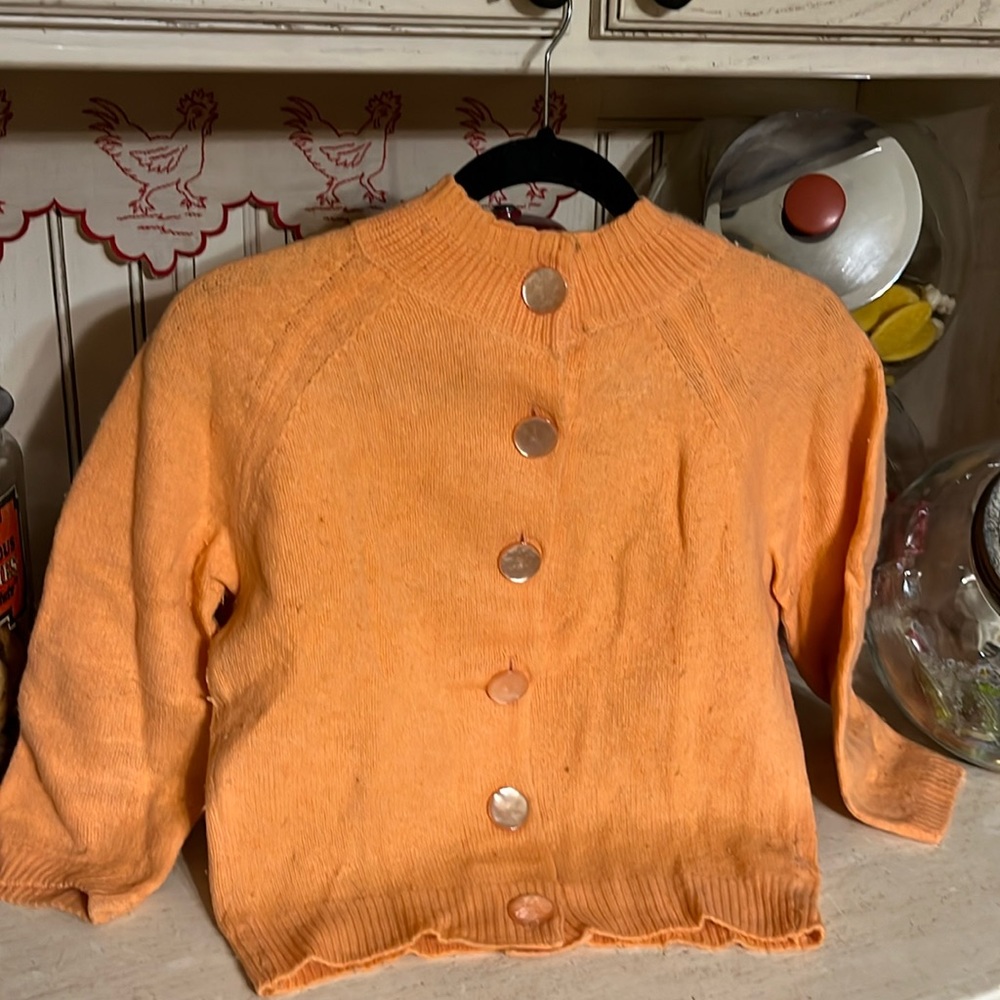 Vintage 50s peach cardigan w oversized buttons has the eye hooks at the neck
